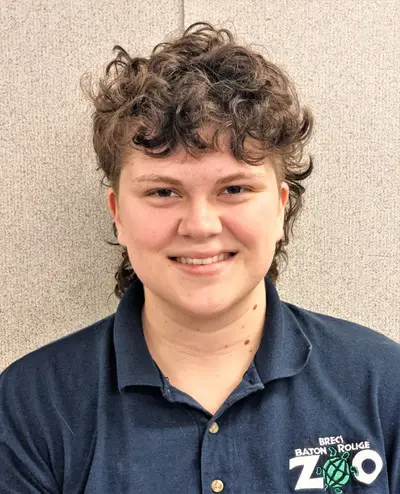 Young person in volunteer collared shirt smiling at camera